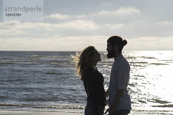 Young couple looking at each other  standing at the sea