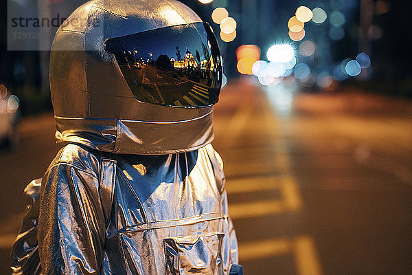 Spaceman on a street in the city at night