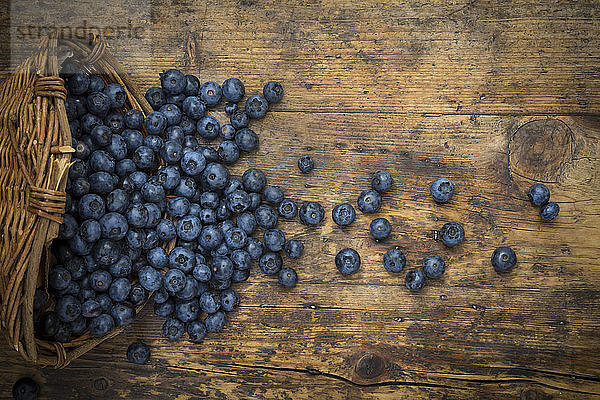 Wickerbasker and blueberries on wood