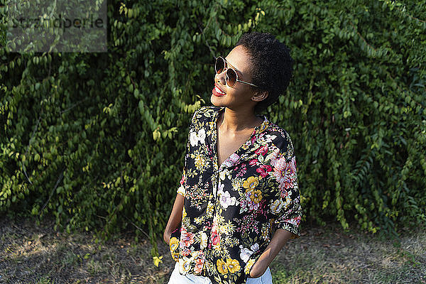 Smiling young woman wearing sunglasses and colourful blouse