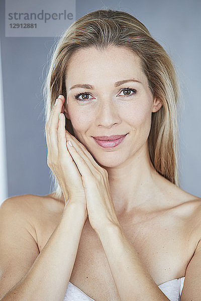 Portrait of smiling blond woman wrapped in towel