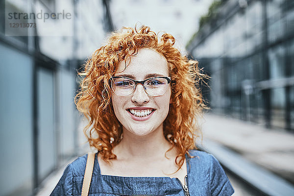 Portrait of a young redheaded woman wearing glasses  smiling