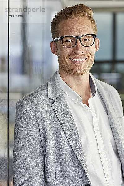 Portrait of smiling redheaded businessman wearing glasses