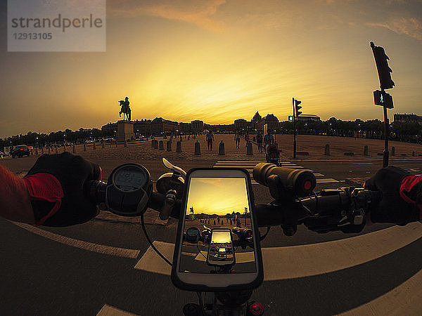 France  Versailles  Place d'Armes  personal perspective of man riding e-bike at sunset