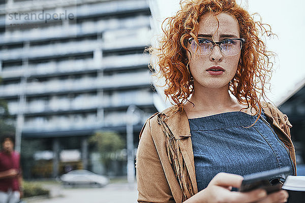 Young woman walking in the city  using smartphone