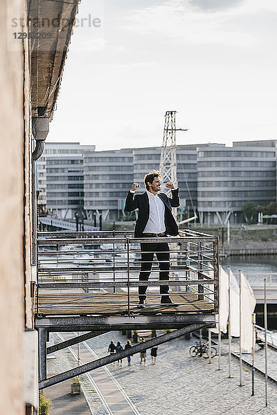 Businessman standing on balcony  flexing muscles
