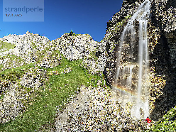 Italy  South Tyrol  hiker at waterfall on path towards Schlinig Pass