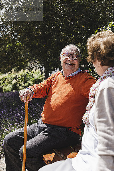 Senior couple sitting on bench in a park  talking