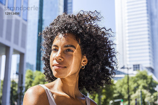 Germany  Frankfurt  portrait of content young woman with curly hair