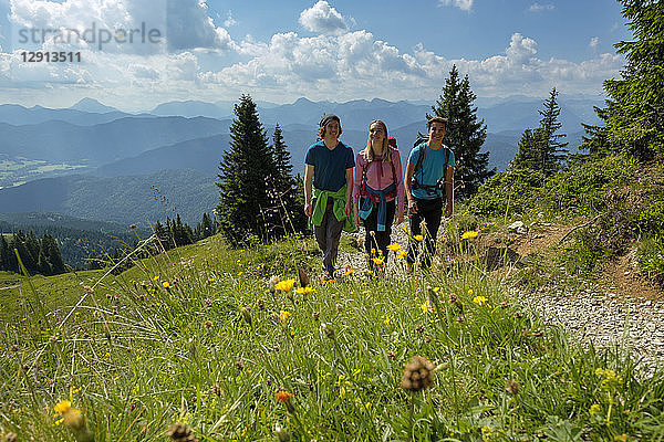 Germany  Bavaria  Brauneck near Lenggries  young friends hiking in alpine landscape