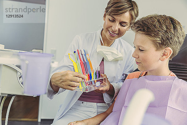 Dentist examining boy's teeth with dental instruments