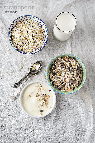 Bowls of granola  oat flakes and natural yoghurt and a glass of milk