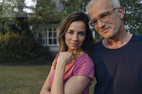 Portrait of smiling mature couple in garden of their home