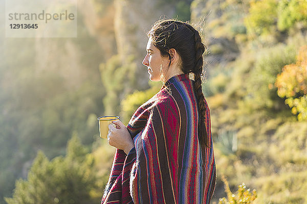 Spain  Alquezar  young woman with coffee mug in nature