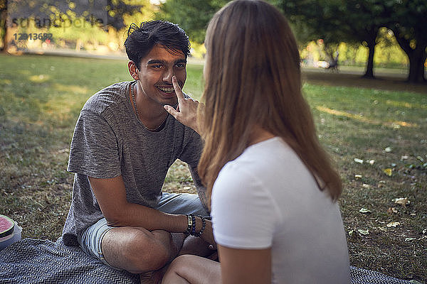 Young couple sitting in park  having fun