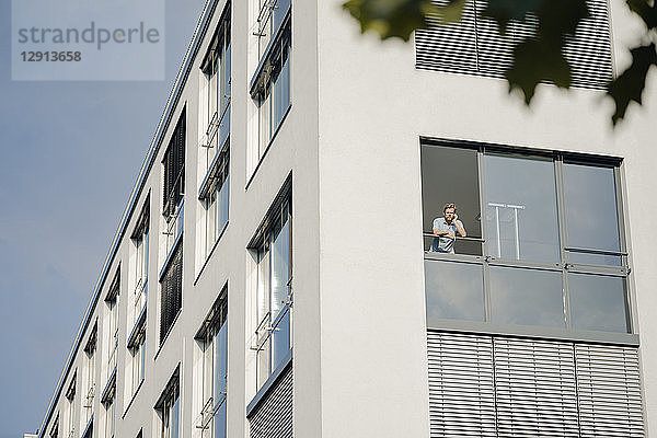 Man talking on the phone  looking out of office window