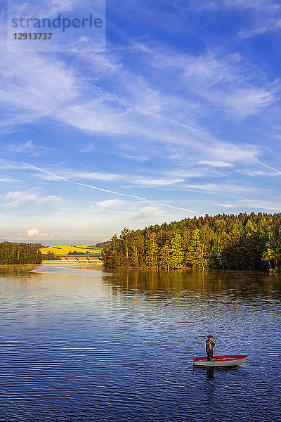 Germany  man in a boat fishing on a dam