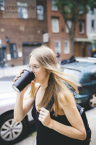 Young woman drinking cup of coffee in NYC