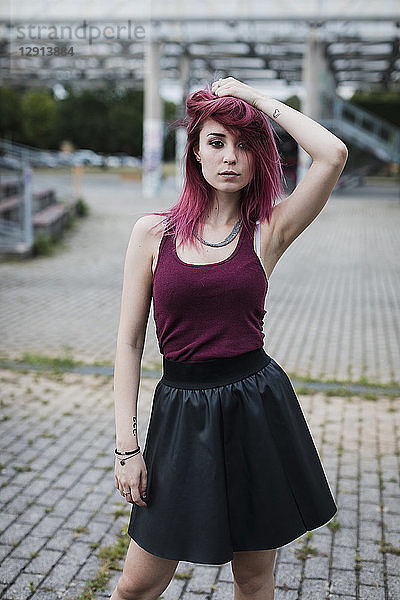 Portrait of young woman with dyed hair posing outdoors