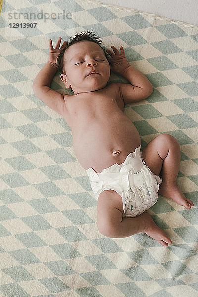 Newborn baby boy lying in diapers on a blanket