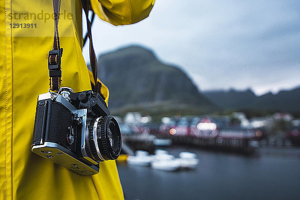 Norway  Lofoten  close-up of man with a camera at a coastal town