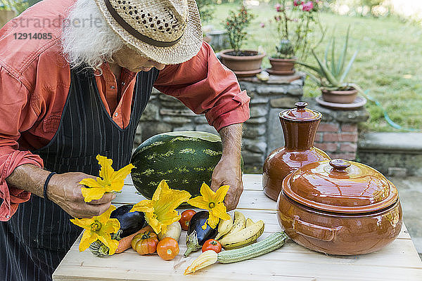 Senior man decorating a table with fruits and vegetables