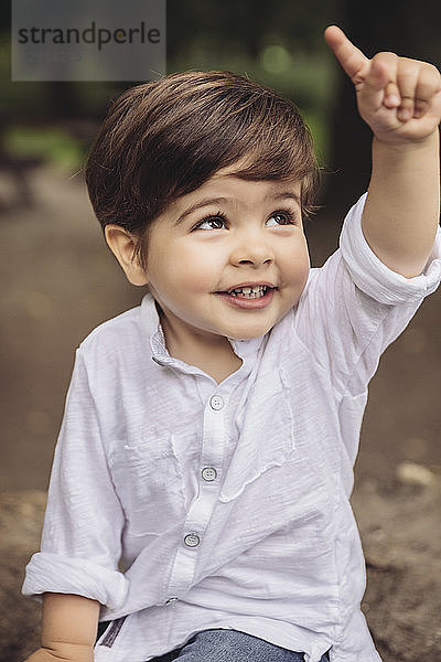 Portrait of smiling toddler raising his finger