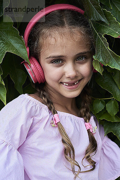 Little girl portrait wearing pink outfit and headphones