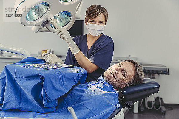 Patient smiling at dental surgeon after successful treatment