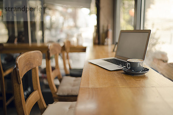 Laptop with blank screen in coffee shop