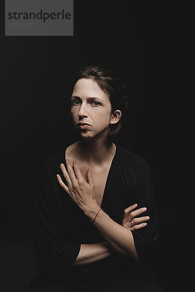 Portrait of woman in front of black background