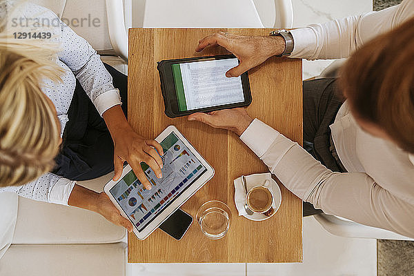 Businessman and businesswoman using tablets in a cafe
