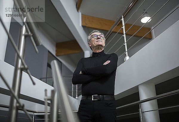 Confident senior businessman standing in office hallway