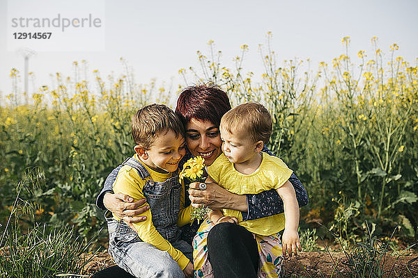 Happy mother with little son and daughter in nature