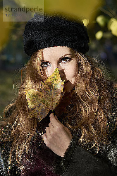 Portrait of redheaded woman with autumn leaf