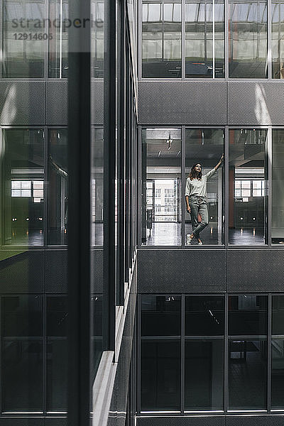 Woman standing at office window  looking up