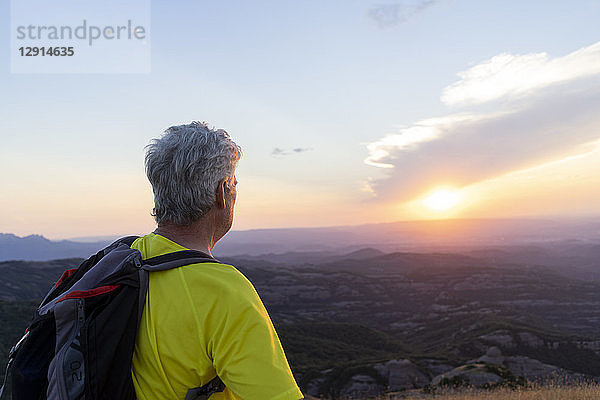 Spain  Catalonia  Montcau  senior man looking at view from top of hill during sunset