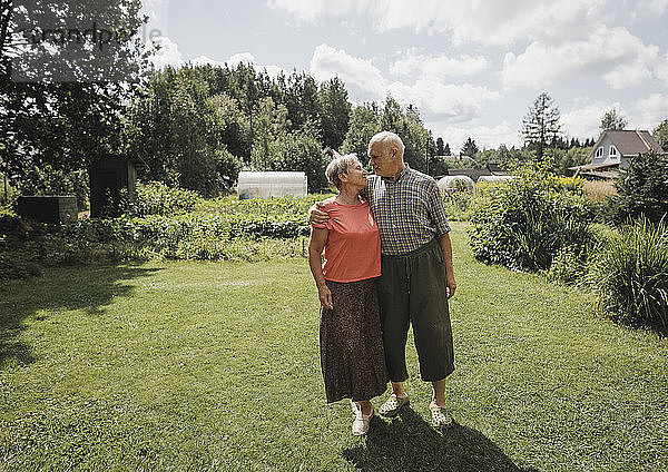 Happy senior couple standing in the garden