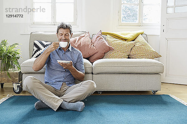 Man sitting on floor  drinking coffee