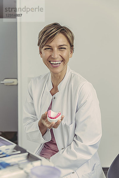 Female dentist holding tooth model