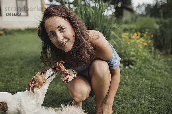 Portrait of smiling woman with Jack Russel Terrier in garden