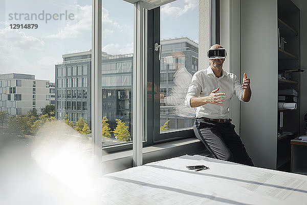 Businessman standing in his office  using VR glasses