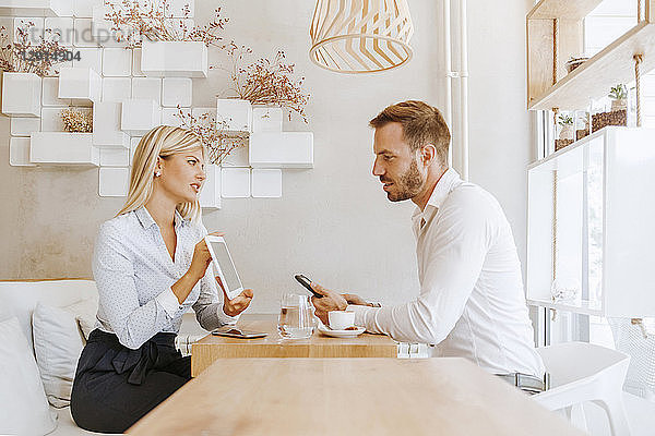 Businessman and businesswoman having a meeting in a cafe