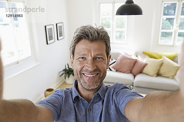 Mature man at home taking a selfie