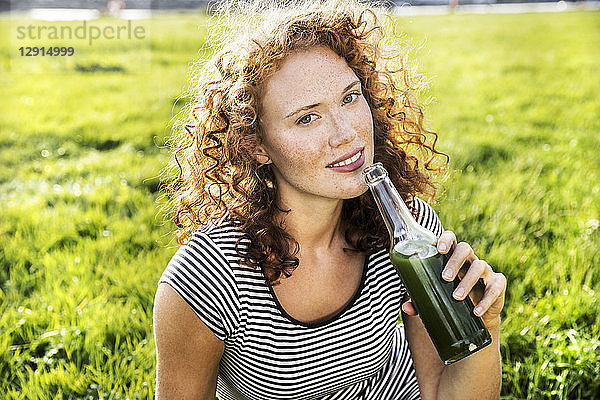 Portrait of redheaded young woman enjoying beverage