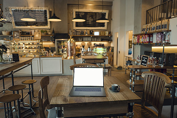 Laptop with blank screen in coffee shop