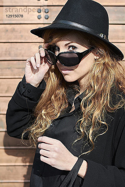 Mid adult woman wearing black hat and sunglasses