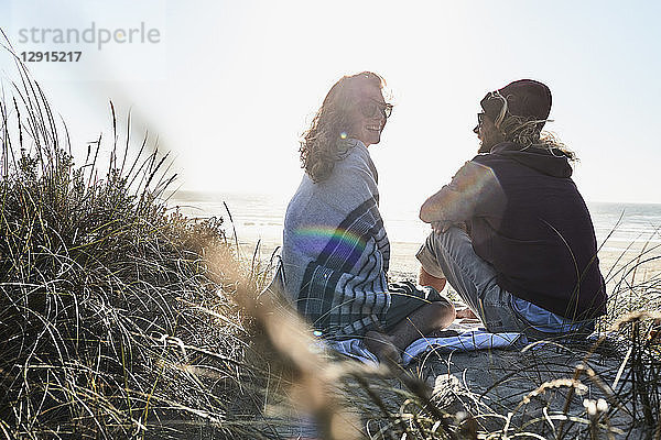 Portugal  Algarve  couple sitting on the beach at sunset