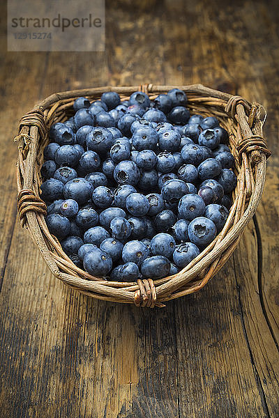 Wickerbasker of blueberries on wood