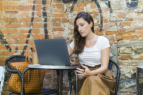 Woman using laptop at an outdoor cafe